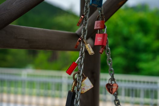 View of many colorful heart-shaped padlocks hanging on a chain. Symbol of eternal love. photo