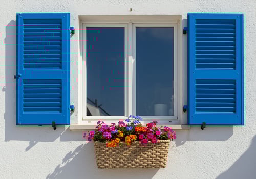 A window with blue shutters and a basket of flowers photo