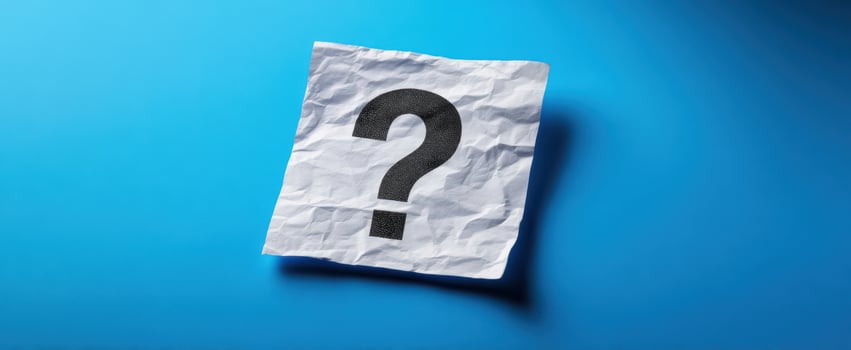 The crumpled paper with a question mark on a vibrant blue background photo