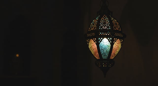 Illuminated lantern, ornate, glowing warm light indoors, room's background shadow photo