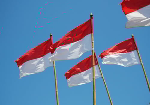 Indonesian flags waving on poles against a clear blue sky for independence day photo