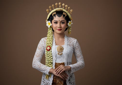 Javanese bride in traditional dress for wedding with solid color backdrop photo