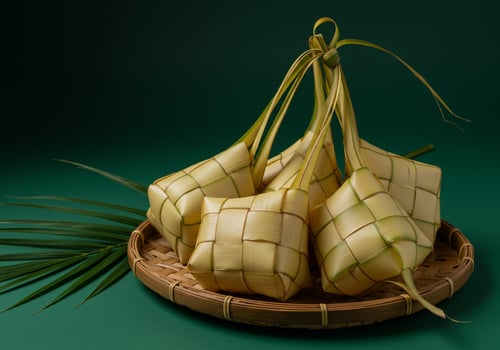 Ketupat rice dumplings served on a mat for Eid al-Fitr celebration in green photo