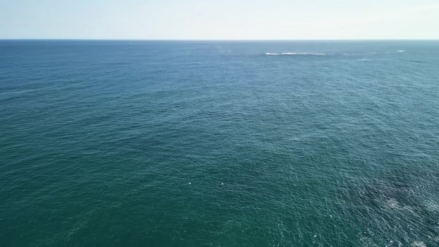 A Beautiful Aerial View of the Tranquil Ocean alongside a Stunning Rocky Coastline within Nature photo