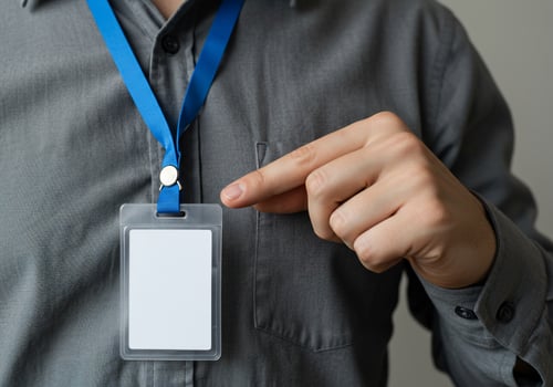 A man holding a lanyard with a badge attached photo