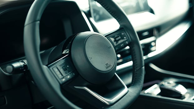 Close-up view of modern car steering wheel showcasing sleek design and high-tech features, emphasizing luxury and innovation in automotive interiors photo