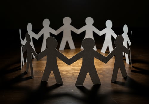 Paper figures in circle on wood table. Represents unity, community, teamwork photo