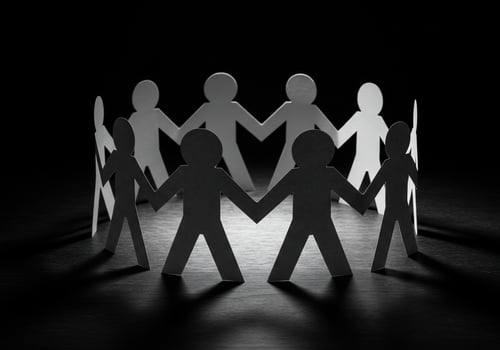 Paper people holding hands in circle showing teamwork, unity on black background photo