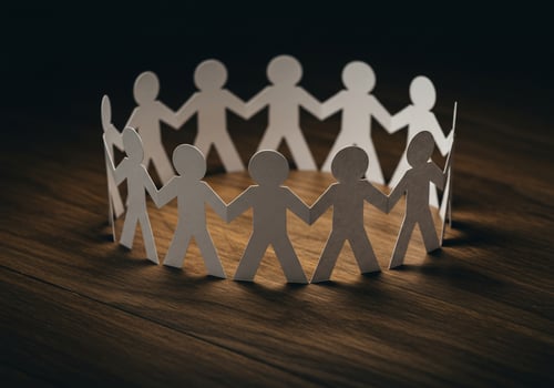Paper people in circle on wooden surface symbolizing unity and teamwork idea photo