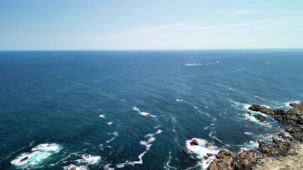Experience the Stunning Ocean View from a Majestic Cliff with Waves and a Clear, Bright Sky photo