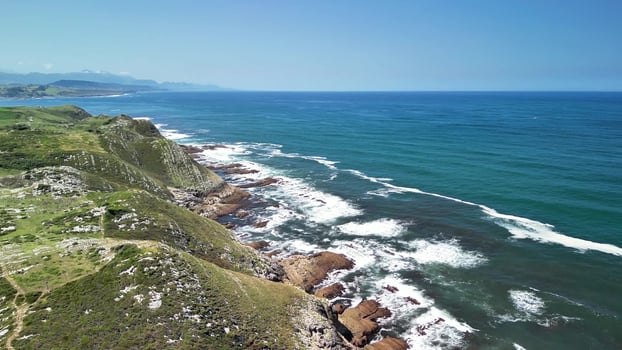 Enjoy the breathtakingly beautiful coastal aerial view featuring rolling waves and majestic cliffs photo