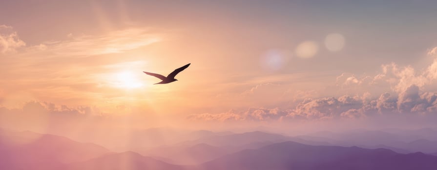 The majestic bird soaring above mountains during a stunning sunset. photo