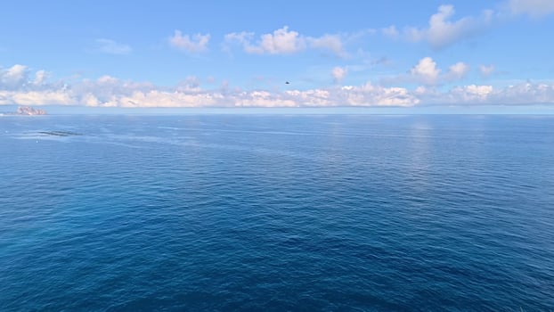 Enjoy a beautiful, tranquil view of the ocean with stunning blue skies and gentle waves rolling in photo