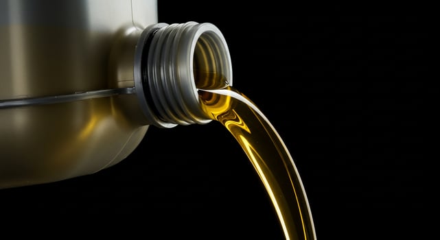 A close up of a metal container with oil pouring out photo