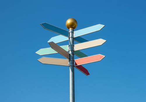 Signpost shows directions against a cloudless sky, useful for navigation, tourism photo