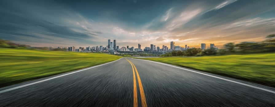 The winding road leading towards a stunning city skyline at sunset photo