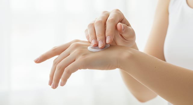 A woman putting cream on her hand photo