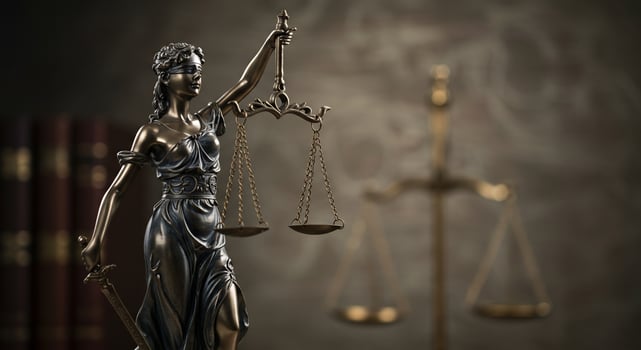 Statue of justice holding scales symbolizing legal fairness with books in background photo