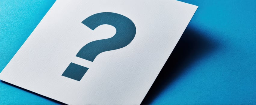 The question mark on white paper against a vibrant blue background. photo
