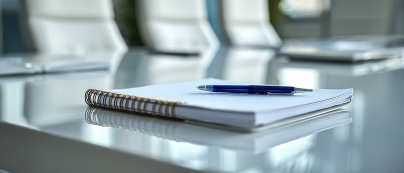 The professional workspace featuring a pen and notebook on a conference table photo