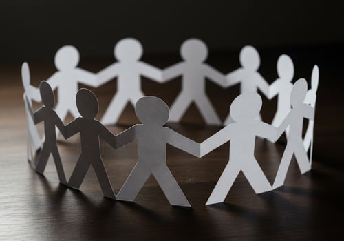 Unity chain of paper people representing cooperation and teamwork on table photo