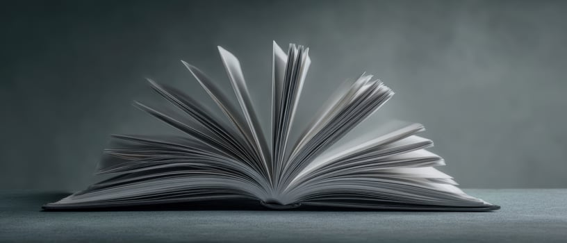 The open book revealing blank pages on a textured surface with soft lighting. photo