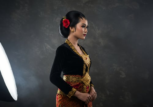 Woman in Javanese Kebaya dress poses for a photoshoot, with studio lighting photo