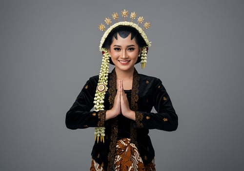 Woman in Javanese Bridal Attire with Hands in Greetings for Cultural Event photo