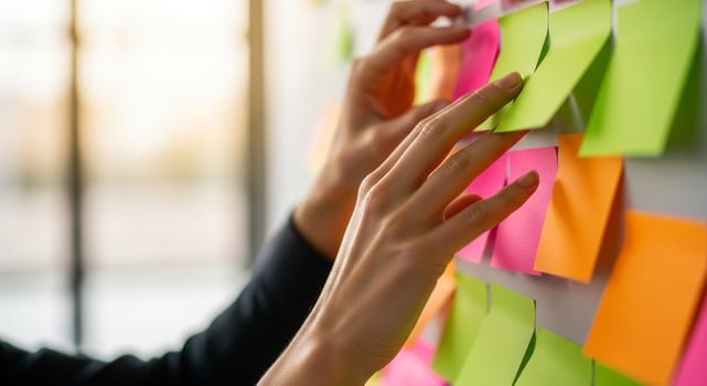 A person is touching a sticky note on a wall photo
