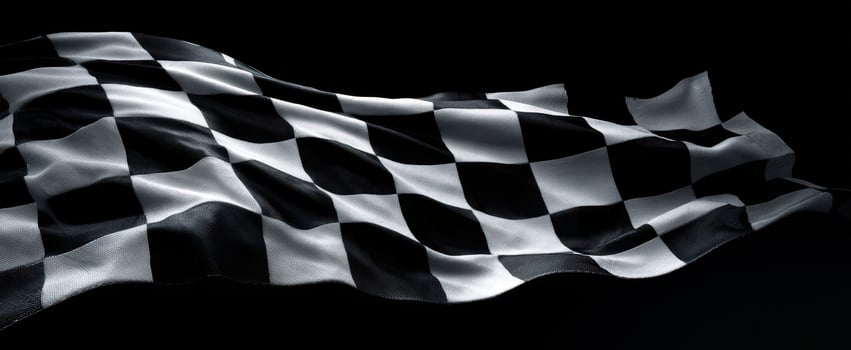 The checkered flag waving dramatically against a dark background. photo