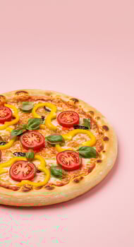A pizza with tomatoes, basil and peppers on a pink background photo