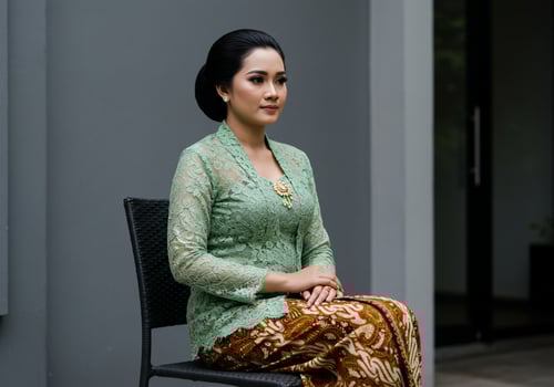 Woman in traditional dress sitting elegantly outdoors, for cultural events or portraits photo
