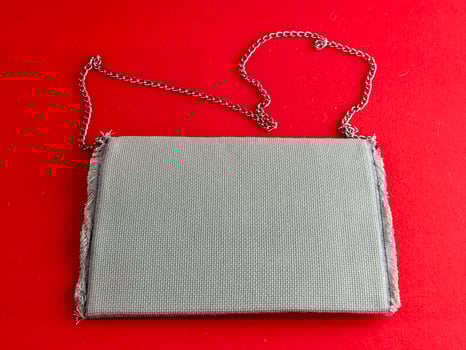 Handmade retro clutch bag on a red background. Vintage bag on a chain handle. photo