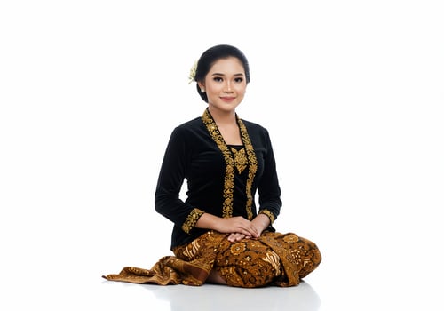Woman kneeling wearing traditional clothes, formal dress on white background photo