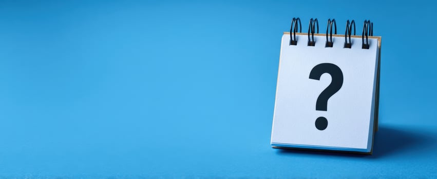 The blank notebook with a question mark on a blue background. photo