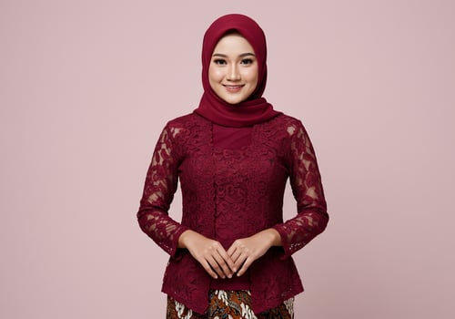 Woman smiles, wearing traditional clothing indoors, on a pink background for fashion photo
