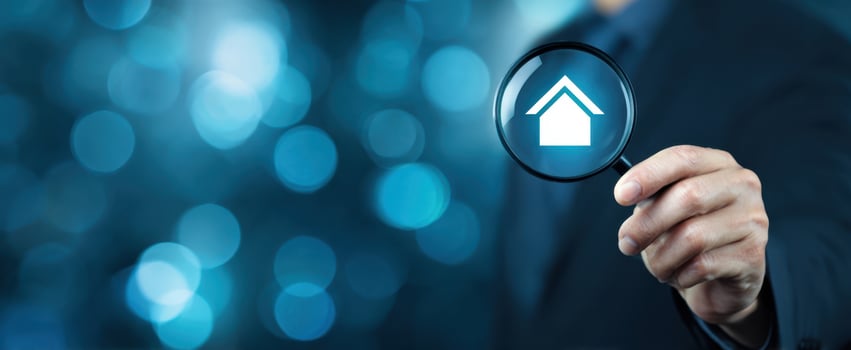 The Magnifying Glass Revealing a House Icon Against a Blurred Blue Background photo