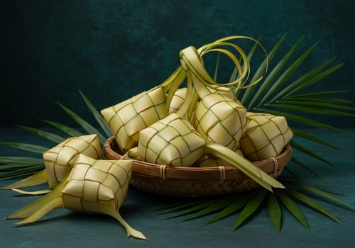 Woven rice pouches in a basket on festive leaves, for holiday food photo