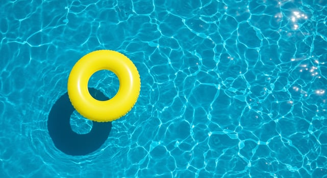 A yellow swimming ring floating in a pool photo
