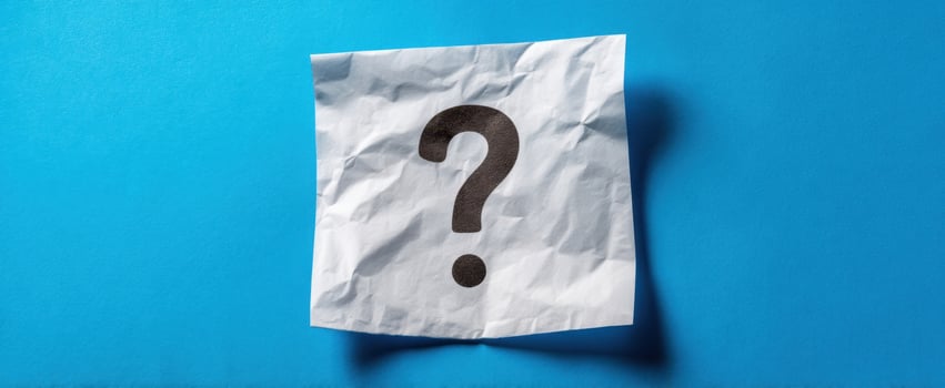 The crumpled paper question mark on a vibrant blue background. photo