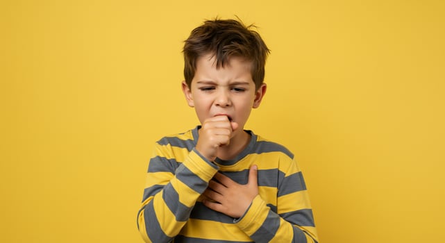 A boy with his hands on his mouth and a yellow background photo