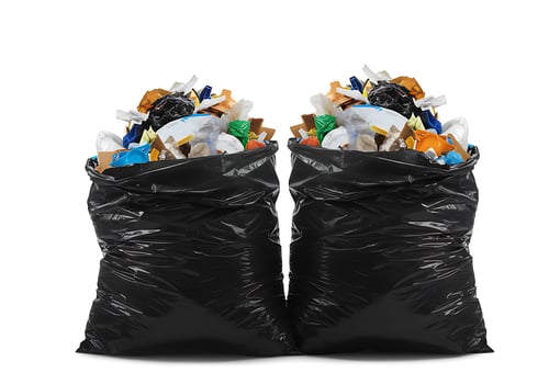 Two black garbage bags filled with various items photo