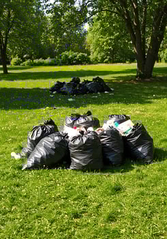 A pile of garbage bags on the grass photo