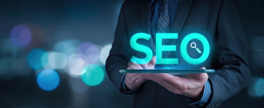 The businessman holding a tablet featuring glowing SEO graphics in a modern setting. photo