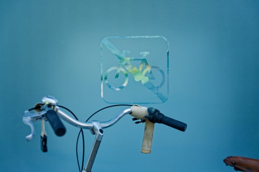 A Bicycle handlebar in front of a no-bicycle sign on a frosted glass wall in cph copenhagen photo