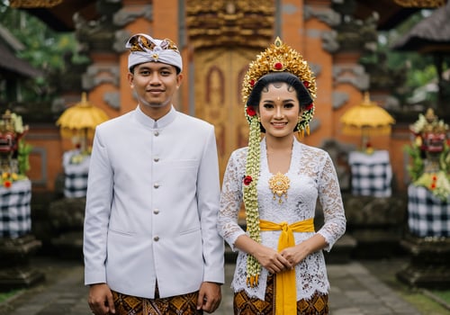 Balinese couple in traditional wedding attire, temple background, cultural event photo