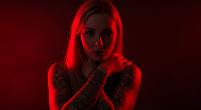 Beautiful blonde woman with tattoos posing, dark red background for commercial use photo