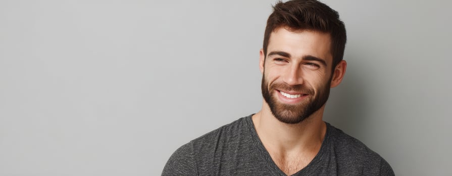 The smiling man with a beard against a gray background. photo