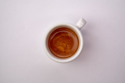 A Close-Up View of a Creamy Espresso Shot in a White Cup, Capturing the Rich Color and Texture of the Brewed Coffee photo