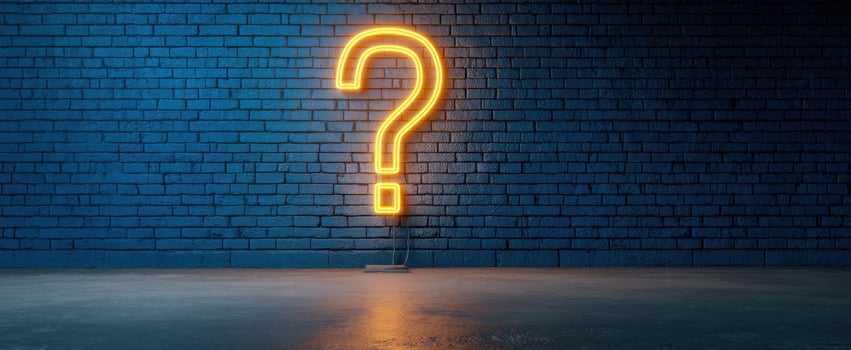The Neon Question Mark Illuminating a Blue Brick Wall in an Urban Setting photo